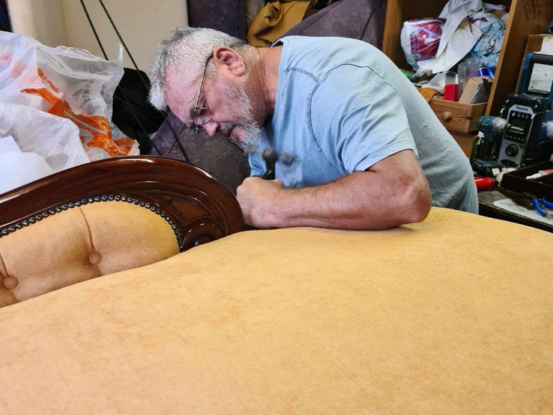 Rob Mann working on the restoration of a chaise longue in France